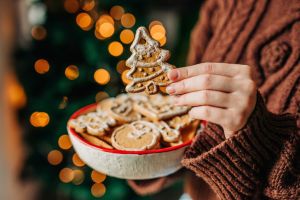 Woman holding gingerbread cookies at home