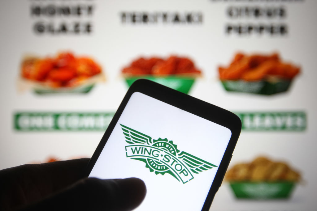 In this photo illustration a Wingstop logo of an US chain of...