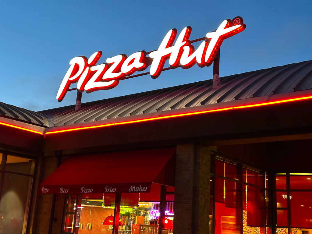 Pizza Hut store sign on building exterior, store frontage