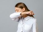 Sneezing woman medical nurse or doctor doing elbow sneeze