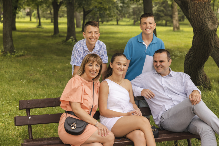 Portrait of an beautiful Caucasian family, parents with teenage children at the public park