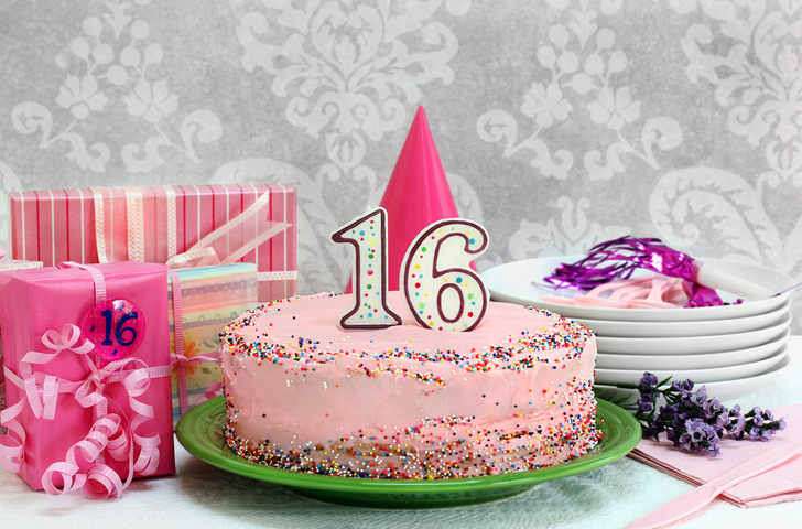 Pink Birthday cake with colorful sprinkles and the number 16 on top.