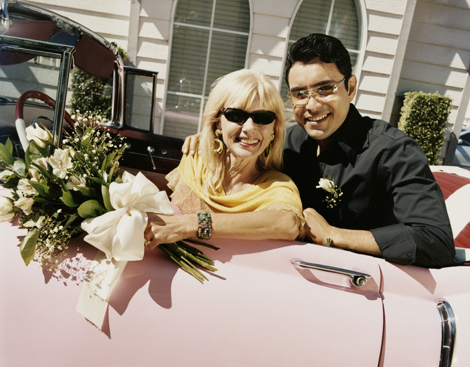 Newlywed Couple Sitting in a Pink 1950's Style Car