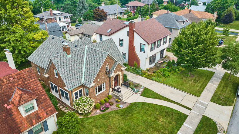Aerial old brick building in neighborhood with landscaped lawns