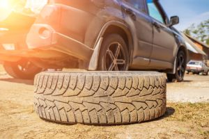 concept of replacing a spare wheel on the road with your own hands. The driver changes the wheel without the help of an auto repair shop