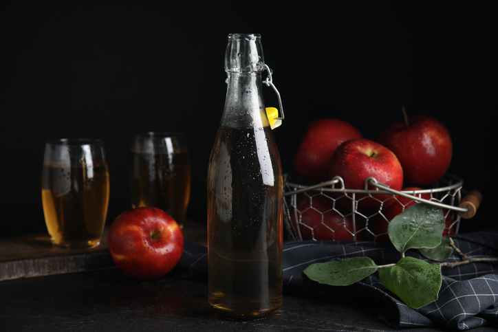 Composition with delicious apple cider on black table