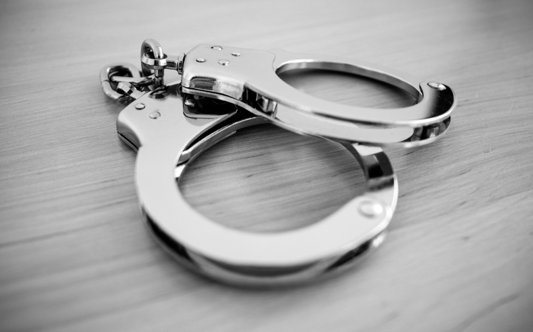 handcuffs on the desk - black and white photo