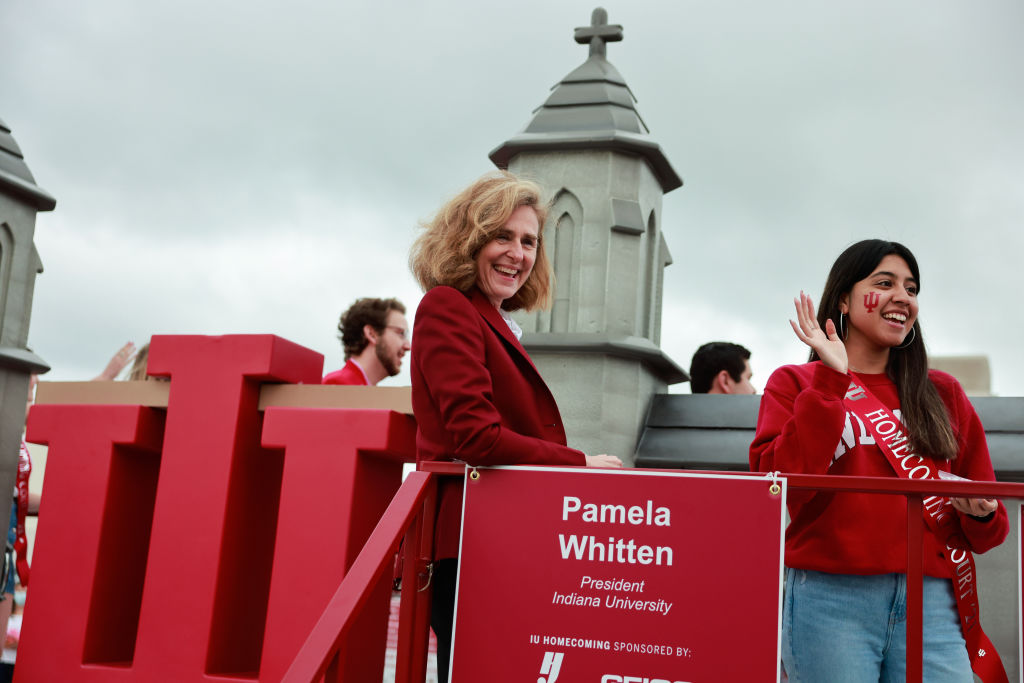 Indiana University President Pamela Whitten, left, rides on...