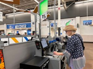 Woman scanning item at self service checkout, Walmart megastore, North Carolina