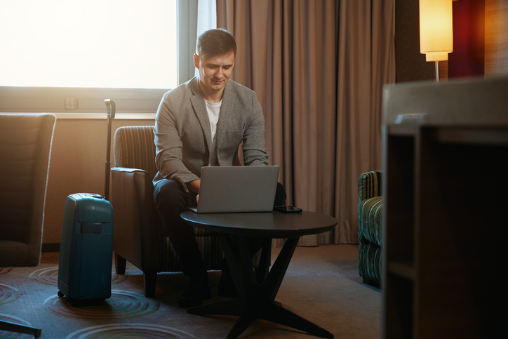 Entrepreneur working on portable computer in hotel room on arrival