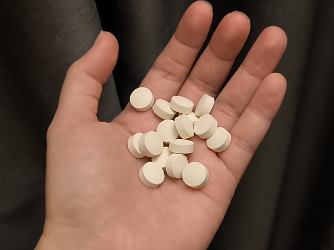 Medicine pills on young women hand