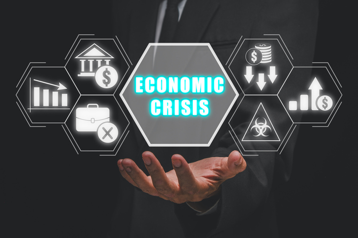 Economic crisis concept, Businessman hand holding economic crisis icon on virtual screen.