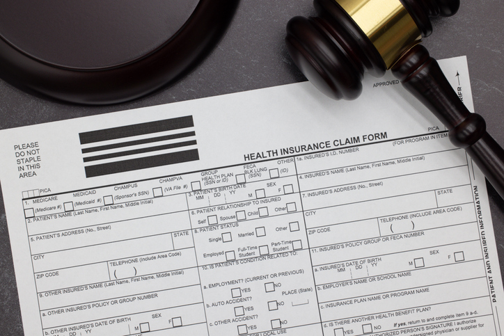 HCFA1500 Health Insurance Claim form with gavel and block on slate desktop