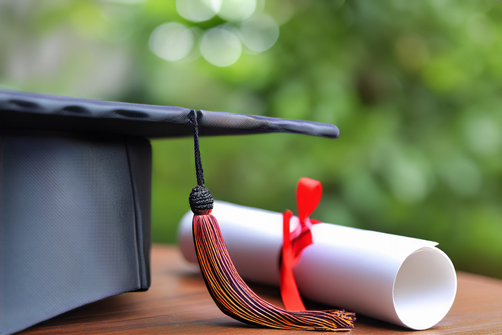 Graduation Cap And Diploma On Table With Books
