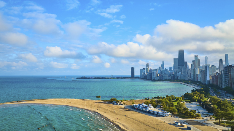 Sandy beach with tourism travel along Lake Michigan with downtown Chicago on sunny summer day