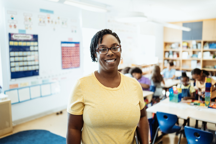 Portrait of mature primary school teacher, smiling and looking at camera