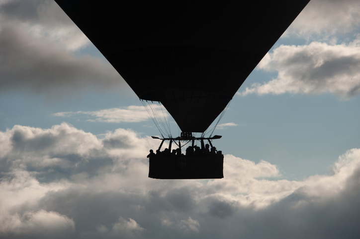 Silhouette of the hot air balloon in Göreme in the morning and the tourists inside
