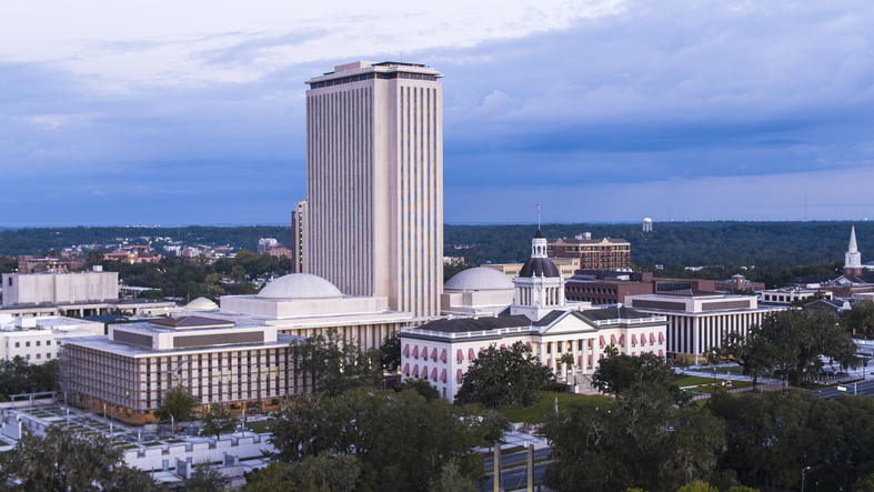 Florida Historic State Capitol contrasts with modern Florida cityscape. Historical architectural domes rise above modern Downtown Tallahassee cityscape in Florida.