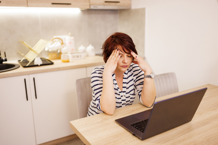 Woman suffering from headache while working from home
