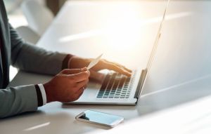 Businessman, typing and credit card with laptop for ecommerce, online shopping and banking investment. Fintech, professional trader or digital finance with hands, loan application or budget in office