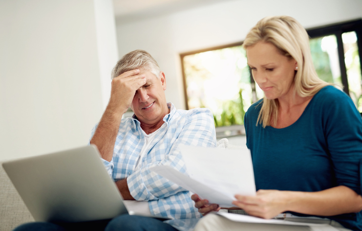 Mature, couple and home with laptop or documents, stressed man and woman planning for financial expenses. Bills, paperwork and online for tax review or budget, insurance contact and sofa in lounge