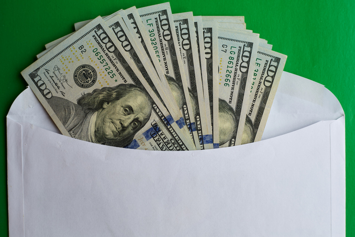 Hundred dollar bills in an envelope on a green background, financial payments, cash bribe, financial postal transfer
