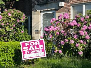 For Sale by Owner sign in yard of house in historic Forest Hills, Queens, New York