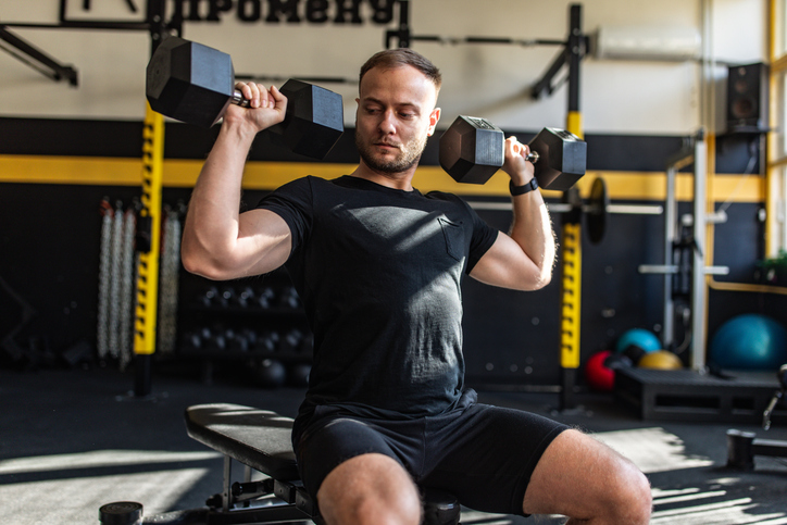 Fit man training with dumbbells