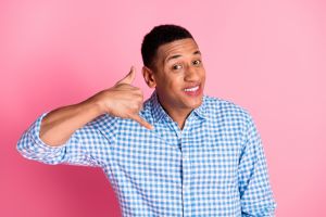 Photo of attractive funny guy wear plaid shirt asking you call him emtpy space isolated pink color background