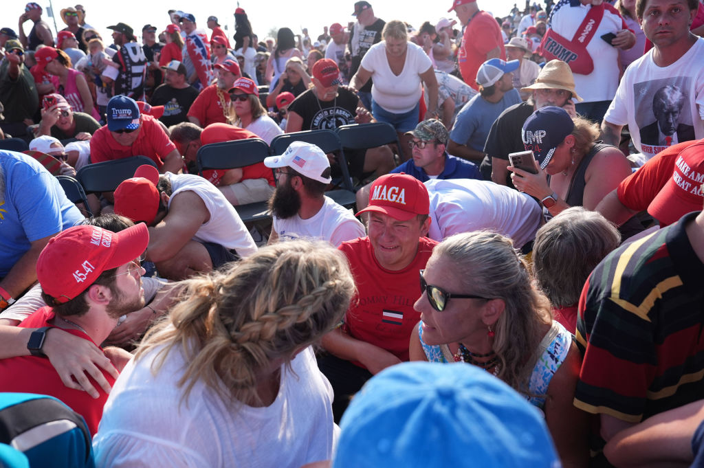 BUTLER, PENNSYLVANIA - July 13: Members of the crowd duck under