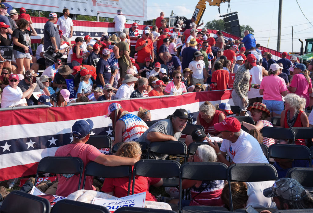BUTLER, PENNSYLVANIA - July 13: Members of the crowd duck under