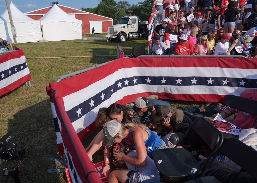 BUTLER, PENNSYLVANIA - July 13: Members of the crowd duck under