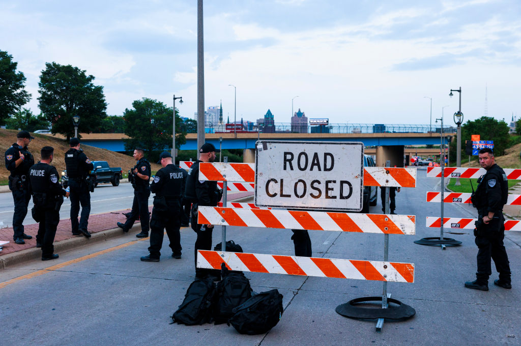 Milwaukee police gather near a "Road Closed" sign on the eve...