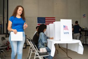 dicerse group of people voting in election day, united states flag with the word vote on the voting booth