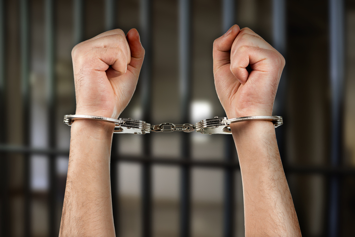Handcuffed hands of a man in prison