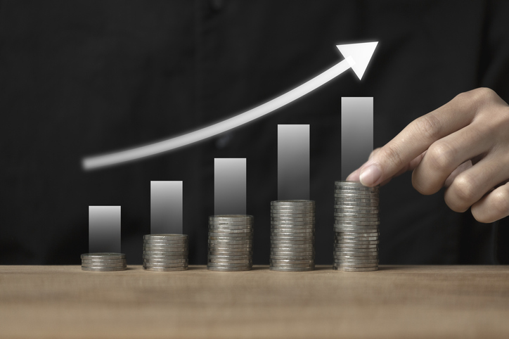 Stack of money with up arrow and percentage symbol in view of business growth is used by financial banks to increase interest rates or mortgages to invest dividends.