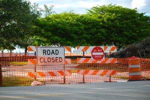 Road closed at construction site with protective fence barrier