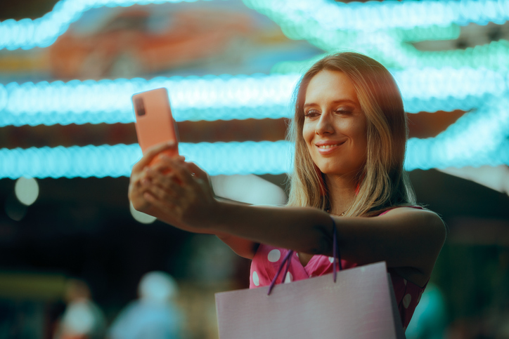 Happy Woman Taking a Smartphone Selfie in an Amusement Park