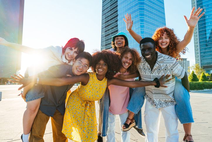 Multiethnic group of young friends meeting and having fun outdoors
