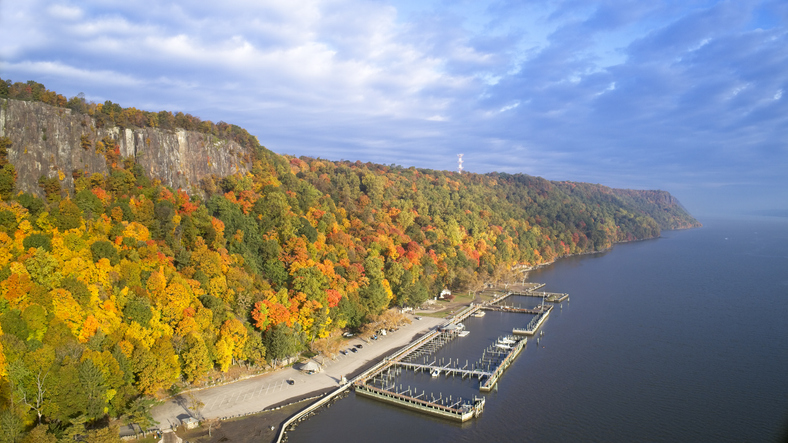 Autumn view of Palisades Cliffs and boat dock on the Hudson River in New Jersey looking north