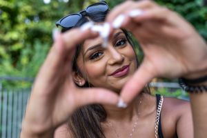 portrait of young teenage woman making heart sign with hands