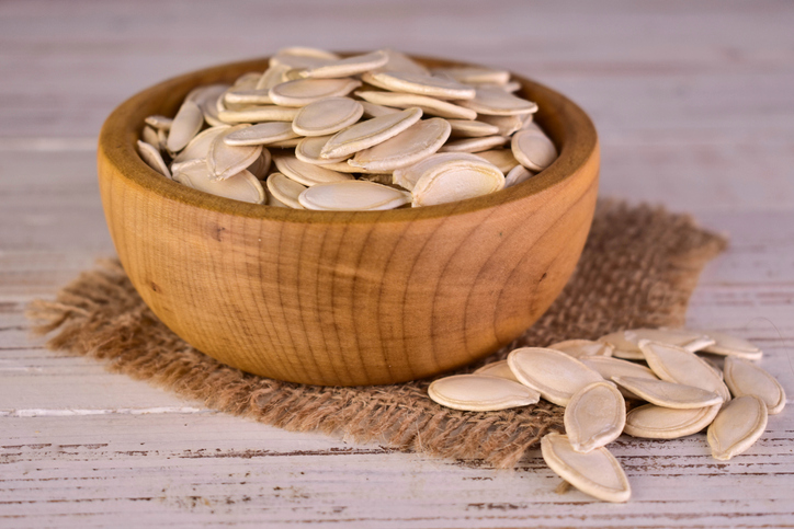Pumpkin seeds in a wooden bowl.Close-up.