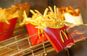 A McDonald?s employee makes French fries...