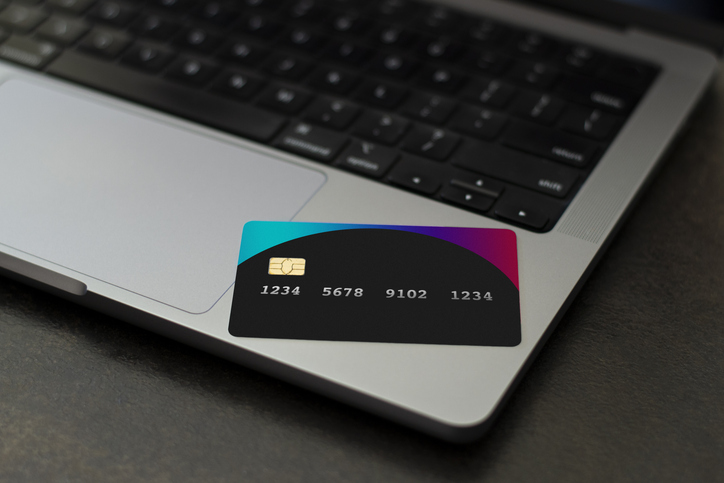 Customer using credit card for payment to owner business. cashless technology and credit card payment concept. through the internet for convenience. black credit card on laptop. premium bank concept