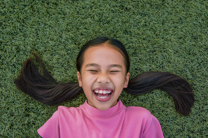 Happy Girl Lying On Field