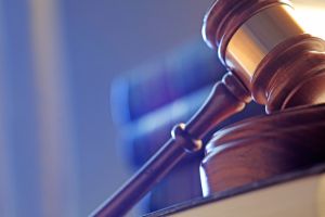 Close Up Of A Gavel In Front of Stack Of Law Books