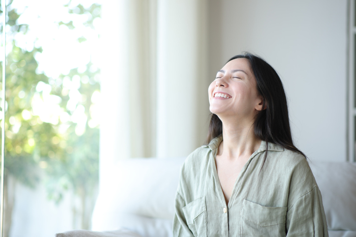 Asian woman breathing and smiling at home