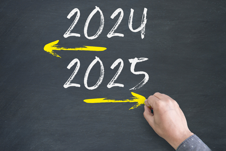 Transitioning from 2024 to 2025 with arrows pointing to the future on a blackboard