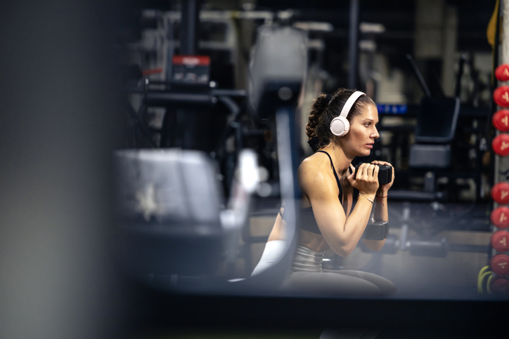 Female listening to music while training hard in the gym.
