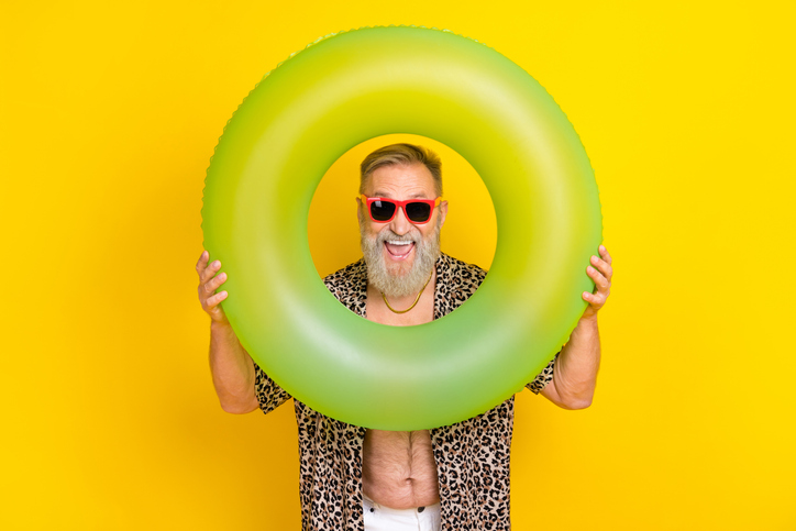 Photo portrait of handsome grandparent smiling hold play buoy dressed stylish leopard print garment isolated on yellow color background